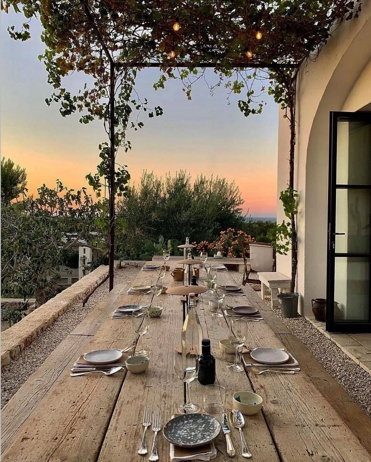 Tavolata apparecchiata all'aperto al tramonto in una masseria pugliese